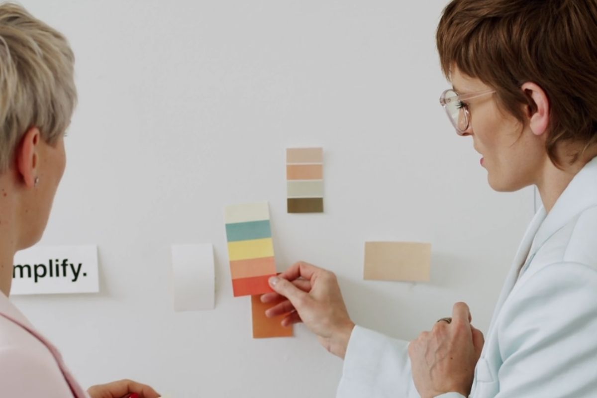 Dve osobe biraju paletu boja i nijansi na zidu, planiranje kolor šeme za kancelarijski prostor